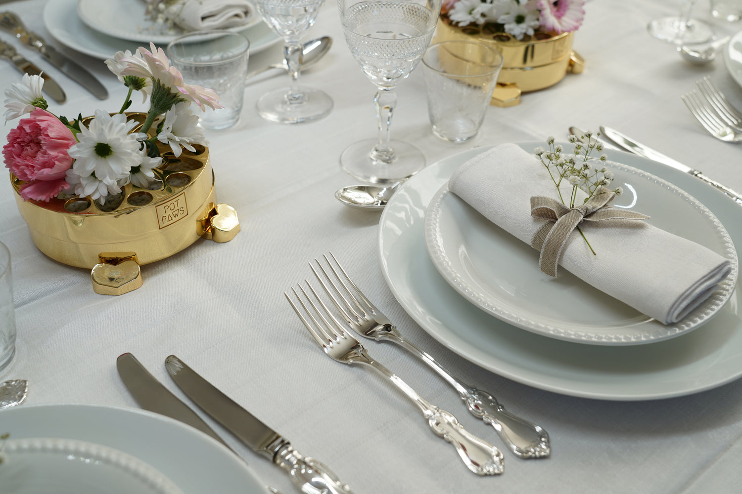 Elegant table setting with gold Pot Paws floral centerpiece