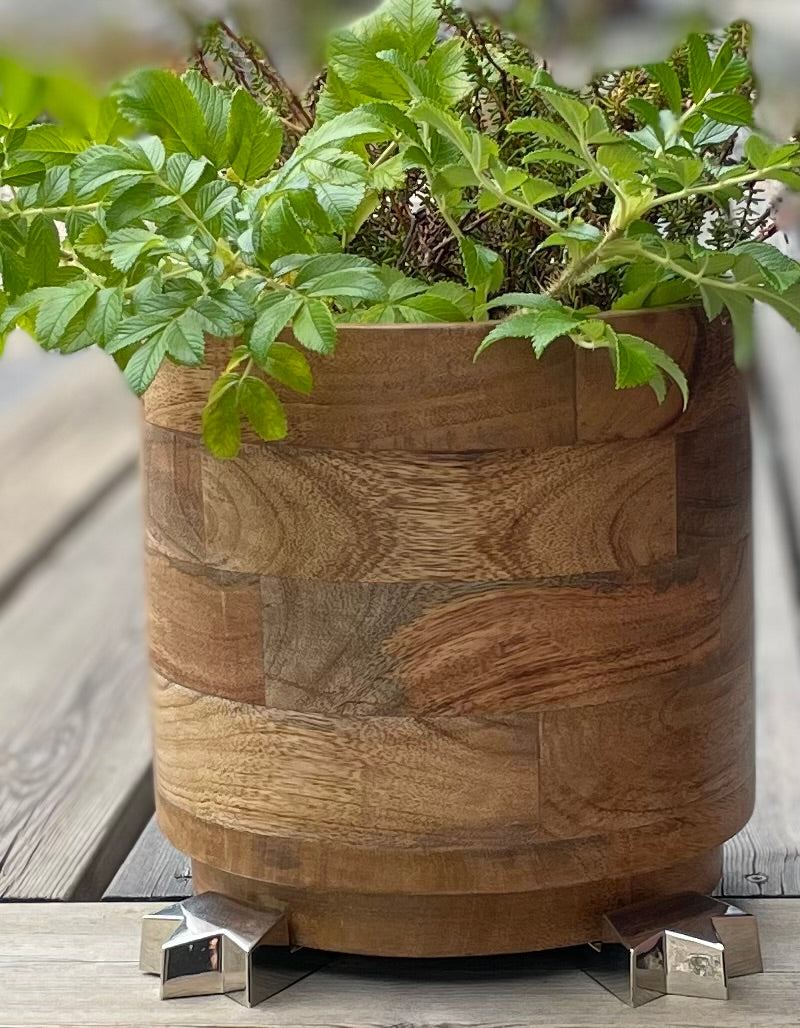 Wooden plant pot elevated on silver POT PAWS pot feet outdoors