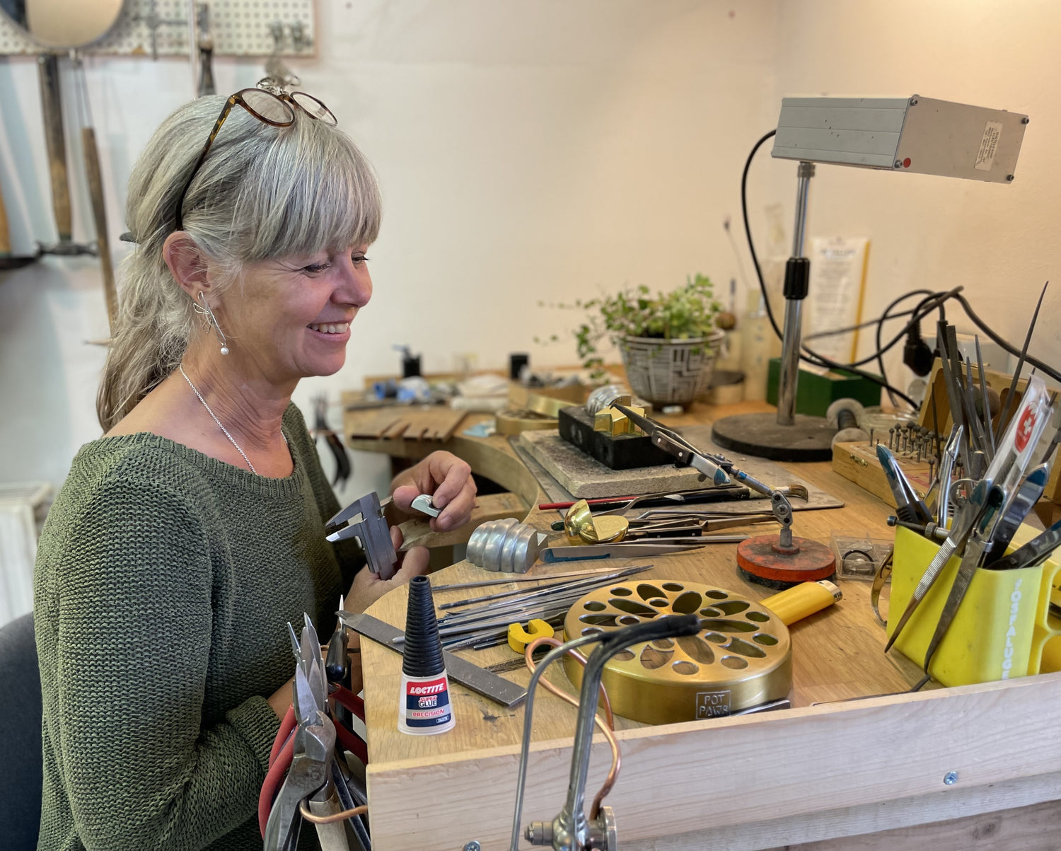 Craftsperson working on Pot Paws kruktassar at a jewelry-style workbench