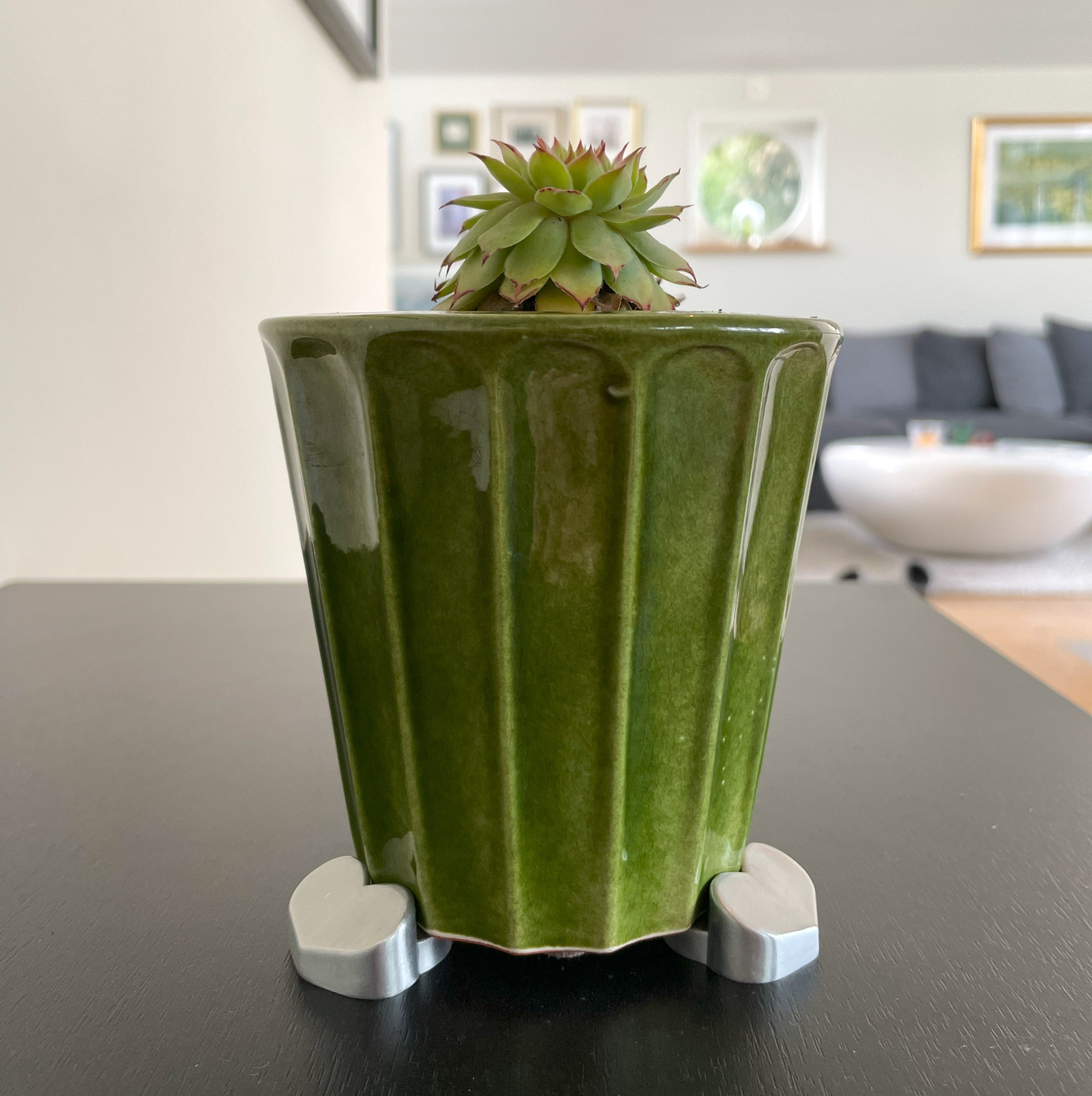 Green ceramic planter with succulent elevated on silver heart-shaped POT PAWS feet