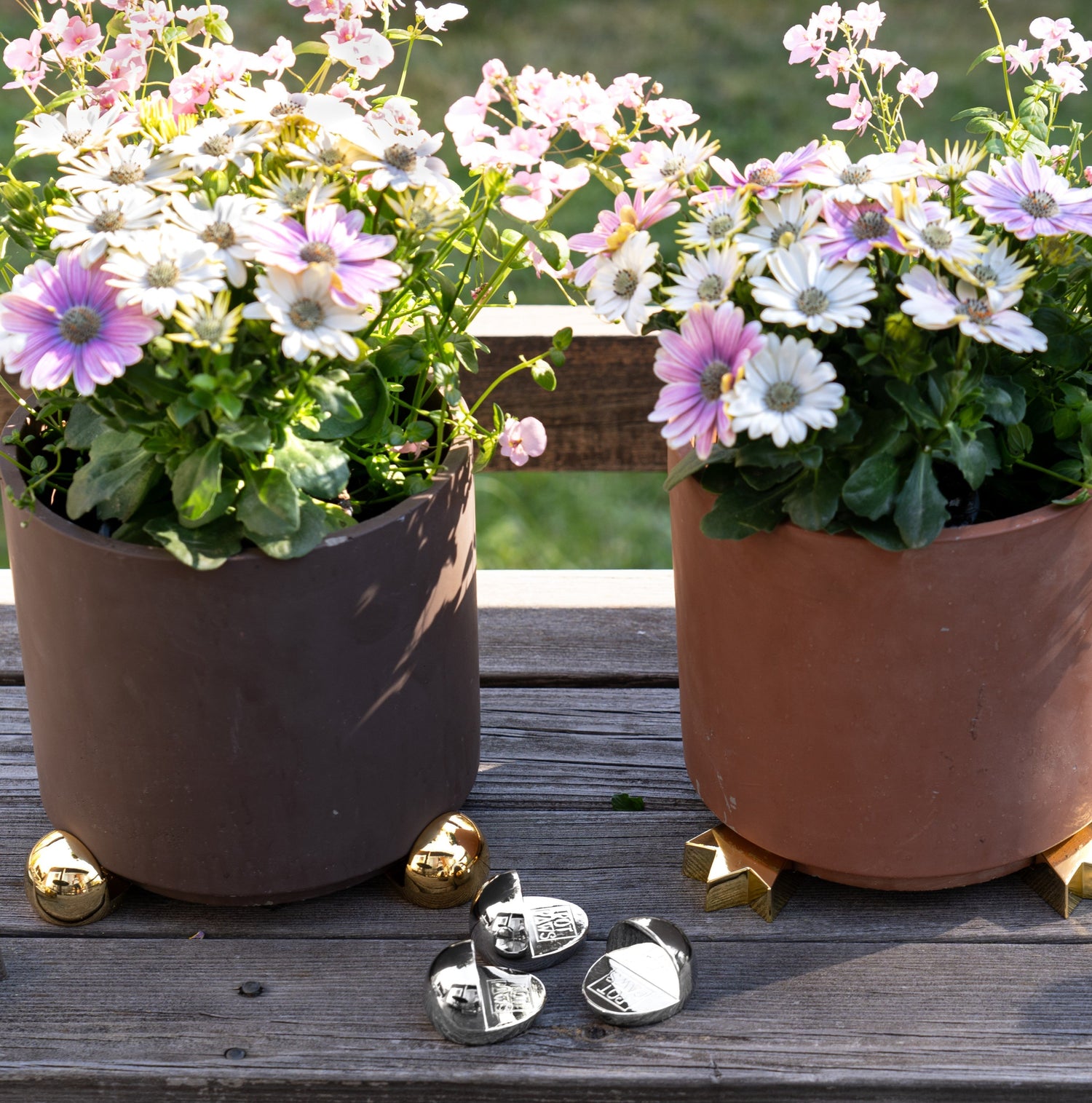 Blommor i kruka med krukfötter i guld och silverfärg